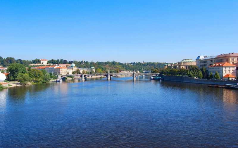 5 - The Mánes Bridge spanning the blue waters of the Vltava River in Prague, Czech Republic, viewed from a vantage point near the historic center